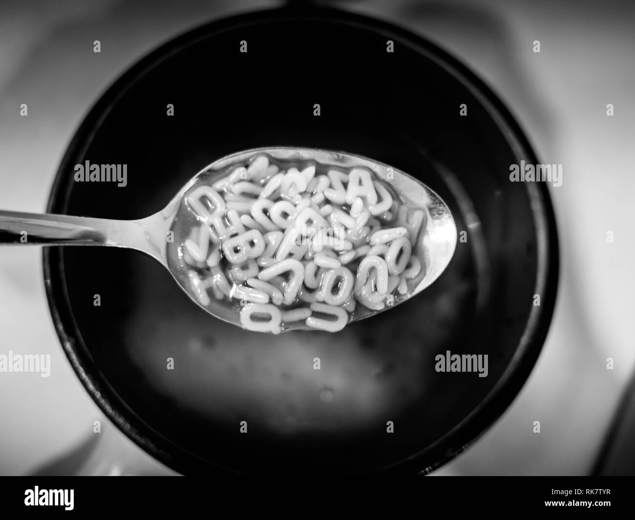 Bild von Schwarzen und Weißen alphabet Nudeln Suppe mit Löffel Stockfoto