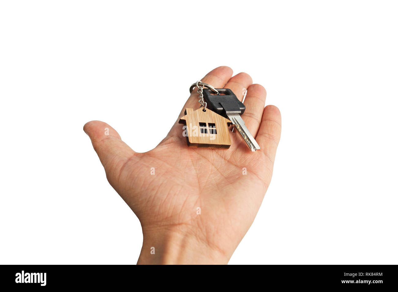 Isolierte männliche Hand in Hand chrom Schlüssel mit Holz- haus zu Key Ring markiert. Abstrakte Darstellung der Hand Übergabe Schlüssel mit kleinen Haus ein Stockfoto