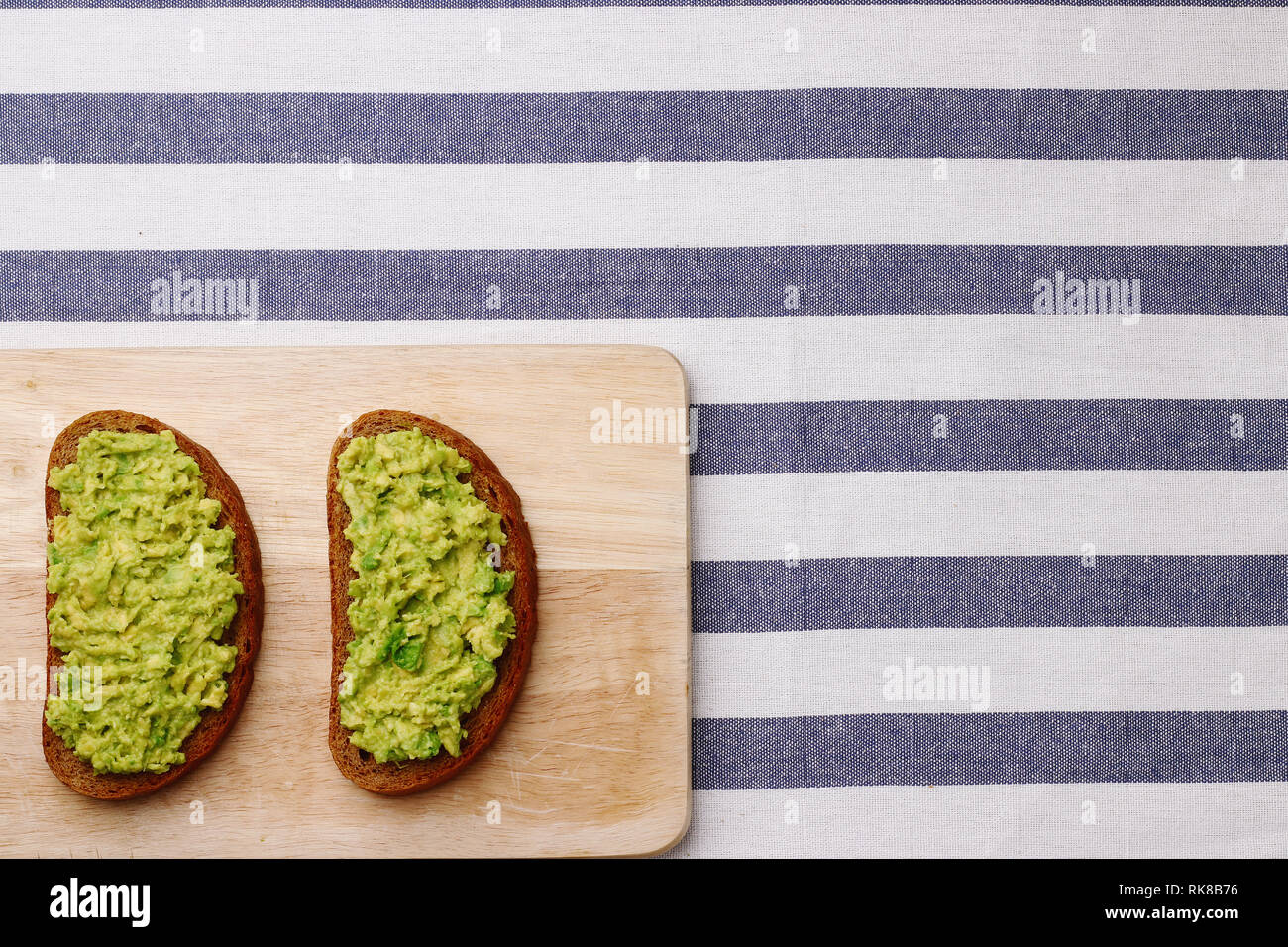 Guacamole Sandwich auf hellen Hintergrund avocado Sandwiches auf Holzbrett und textile Draufsicht Stockfoto