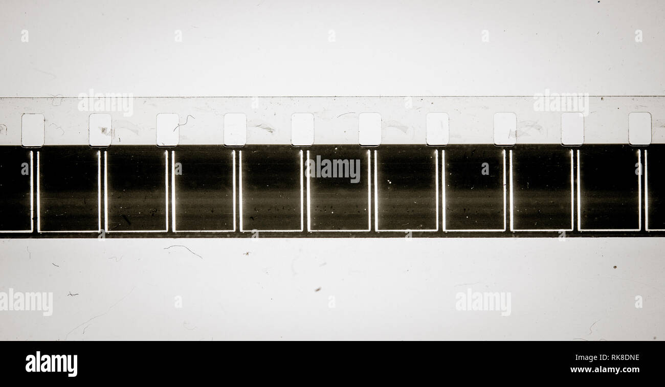 Extreme Nahaufnahme der leeren schwarzen Rahmen auf 8mm Film Strip auf schmutzigen Hintergrund Stockfoto
