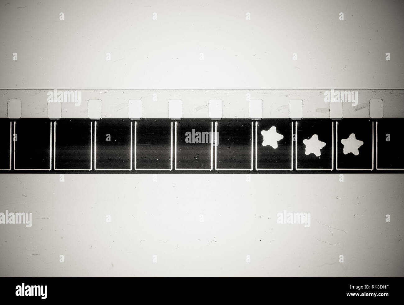 Extreme Nahaufnahme der schwarze Rahmen und Sterne Zeichen auf 8mm Film Strip auf schmutzigen Hintergrund Stockfoto