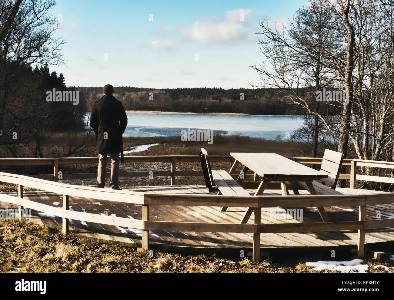 Ansicht der Rückseite des Mann in Picknickplatz am zugefrorenen See Oxundasjon, Upplands Vasby, Stockholm, Schweden, Skandinavien suchen Stockfoto