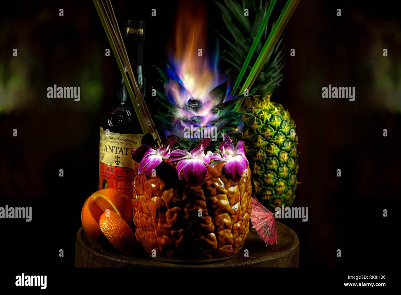 Wunderschöner Rum-Sharing-Cocktail in einem Ananasball serviert Mit Früchten mit einer Garnierung auf Feuer Stockfoto