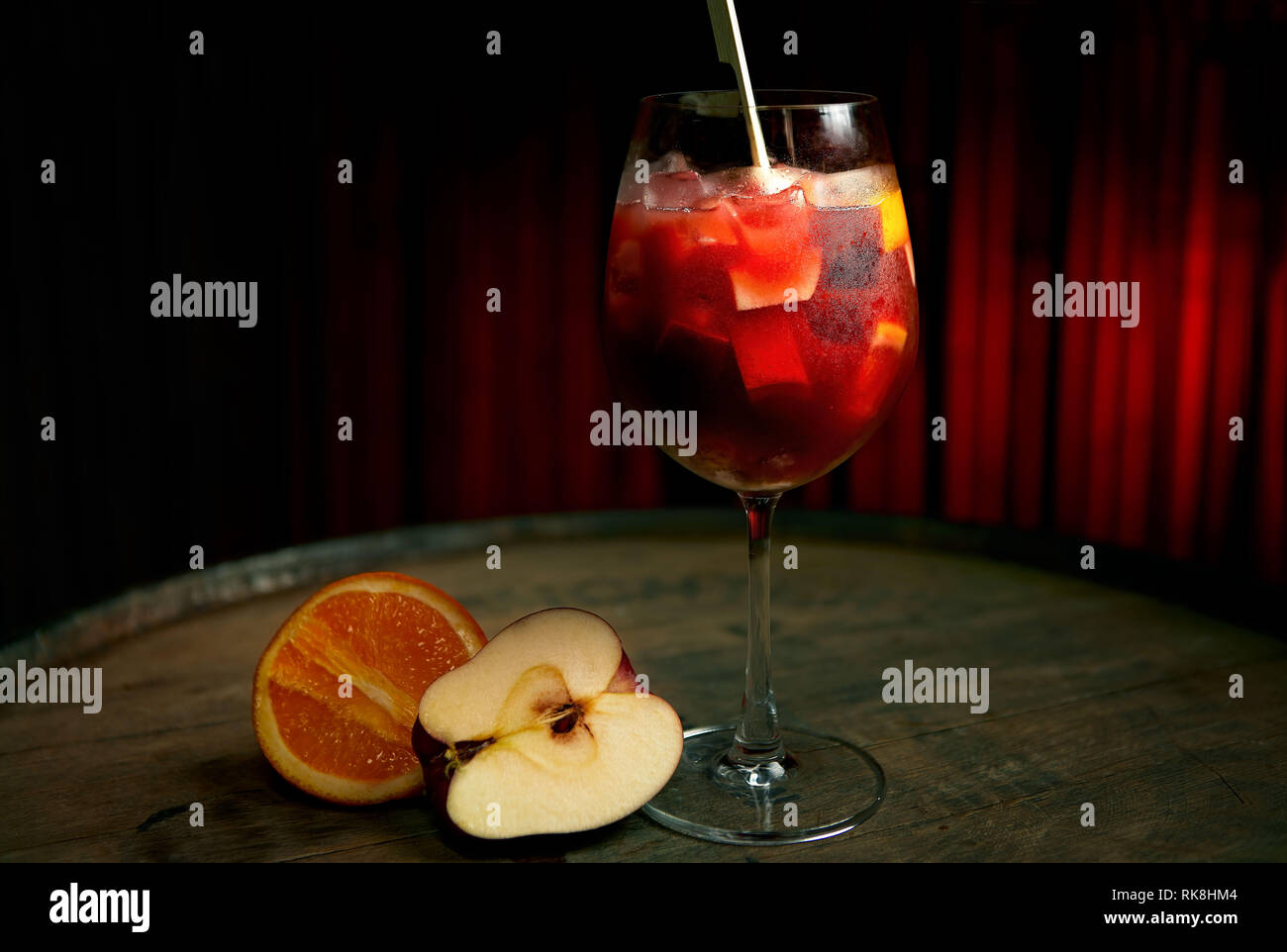 Fruchtige rote Sangria in einem großen Rotweinglas serviert Mit Stücken von Apfel und Orange Stockfoto