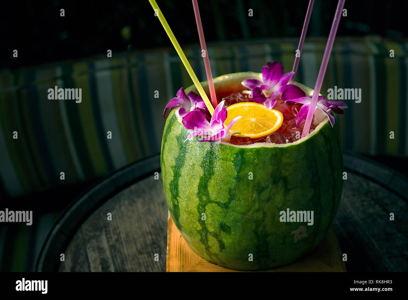 Frische Wassermelone für einen gemeinsamen Cocktail mit Strohhalmen und verwendet Orchideen garniert Stockfoto