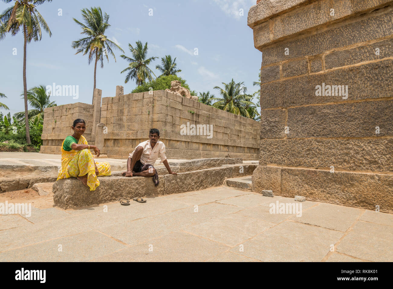 Ein Paar, das in traditioneller Kleidung Rest in der Nähe der Lakshmi Narasimha Tempel in Ha, Pi, Karnataka, Indien Stockfoto