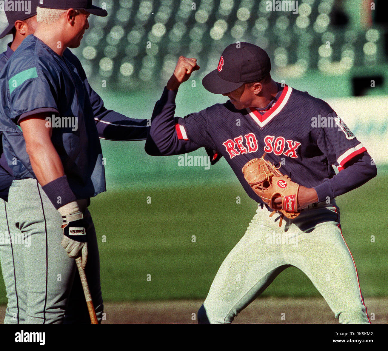 Red Sox Pitcher Pedro Martinez zeigt aus seinen Arm Stärke als Seattle Mariners Ken Griffy jr (hinten links) drückt seine bicep vor dem Spiel im Fenway Park in Boston, Ma USA Mai 12,1999 Foto von Bill Belknap Stockfoto