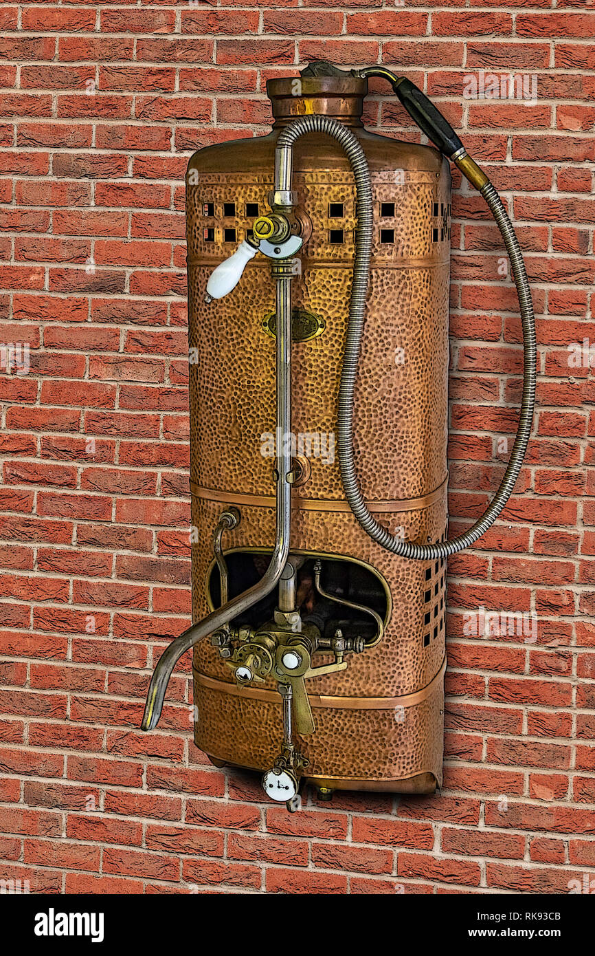 Vintage Gas Wasser Heizung mit Dusche auf der Backsteinmauer. Retro Durchlauferhitzer mit Tippen. Stockfoto