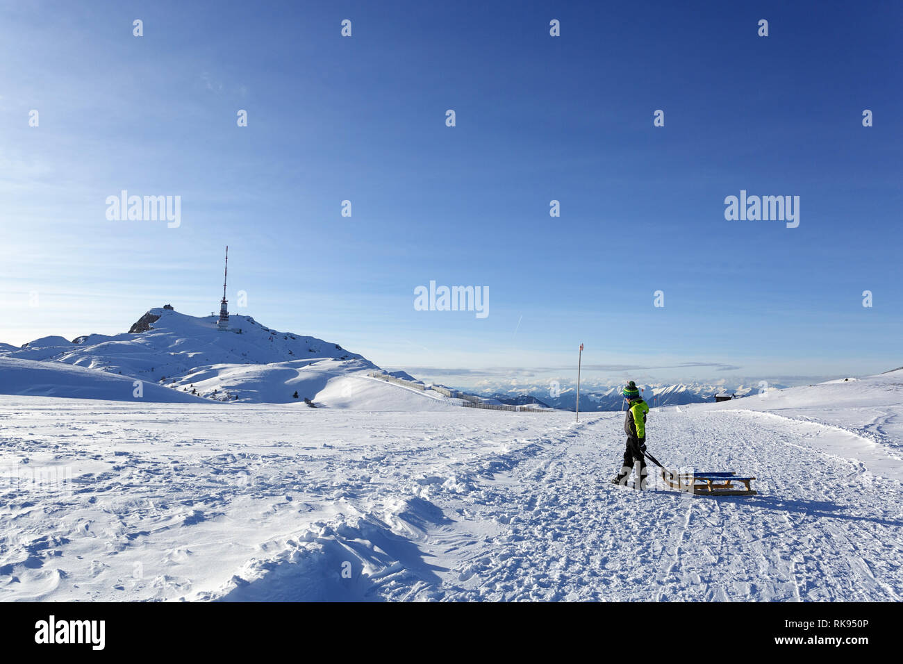 Junge wandern mit Schlitten im Winter oben auf dem Berg Dobratsch, Kärnten, Österreich Stockfoto
