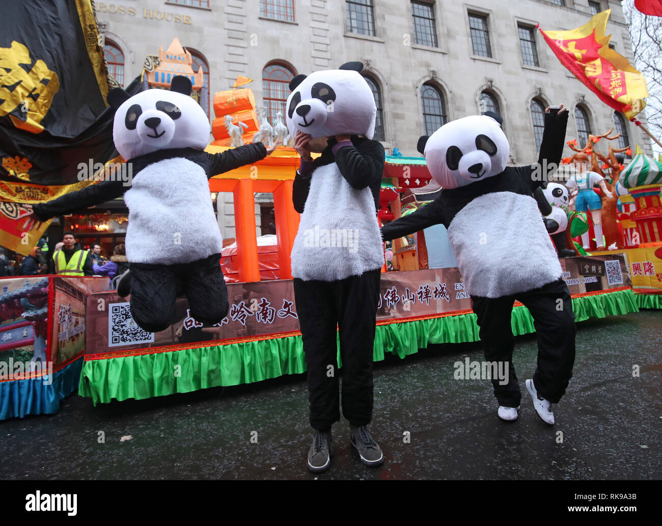 Künstler, die an einer Parade mit Kostümen, Löwentanz und schwimmt, während chinesische Neujahrsfest in Chinatown, London, die das Jahr des Schweins. Stockfoto