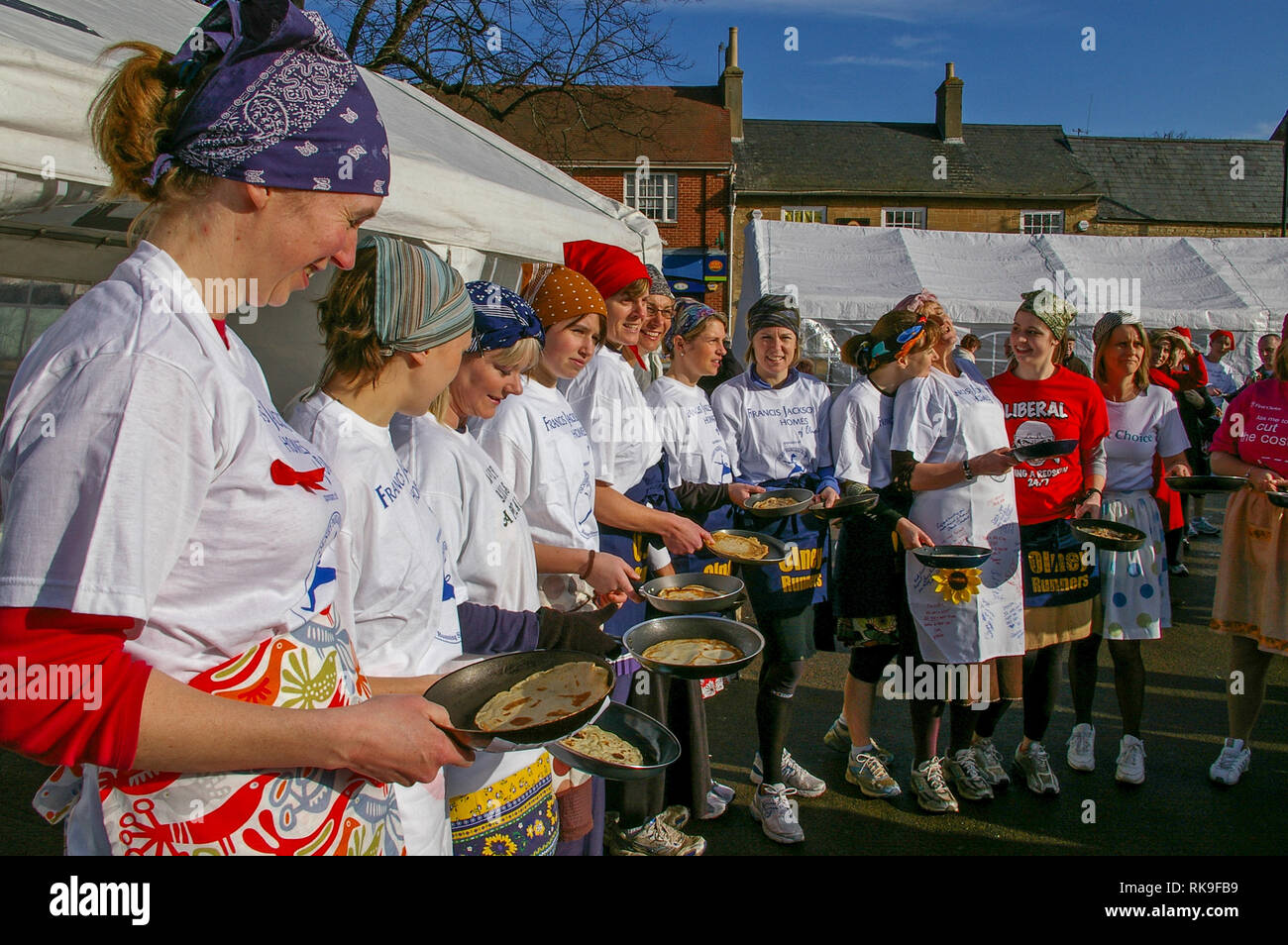 Lächelnde Damen oben Futter in den Marktplatz für den Beginn der berühmten olney Pancake Race, sagte, das älteste der Welt, Buckinghamshire, Großbritannien Stockfoto