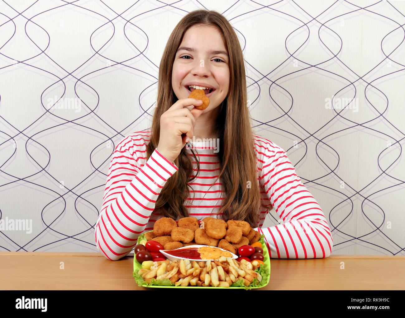 Hungrig Jugendmädchen isst Chicken Nuggets Stockfoto