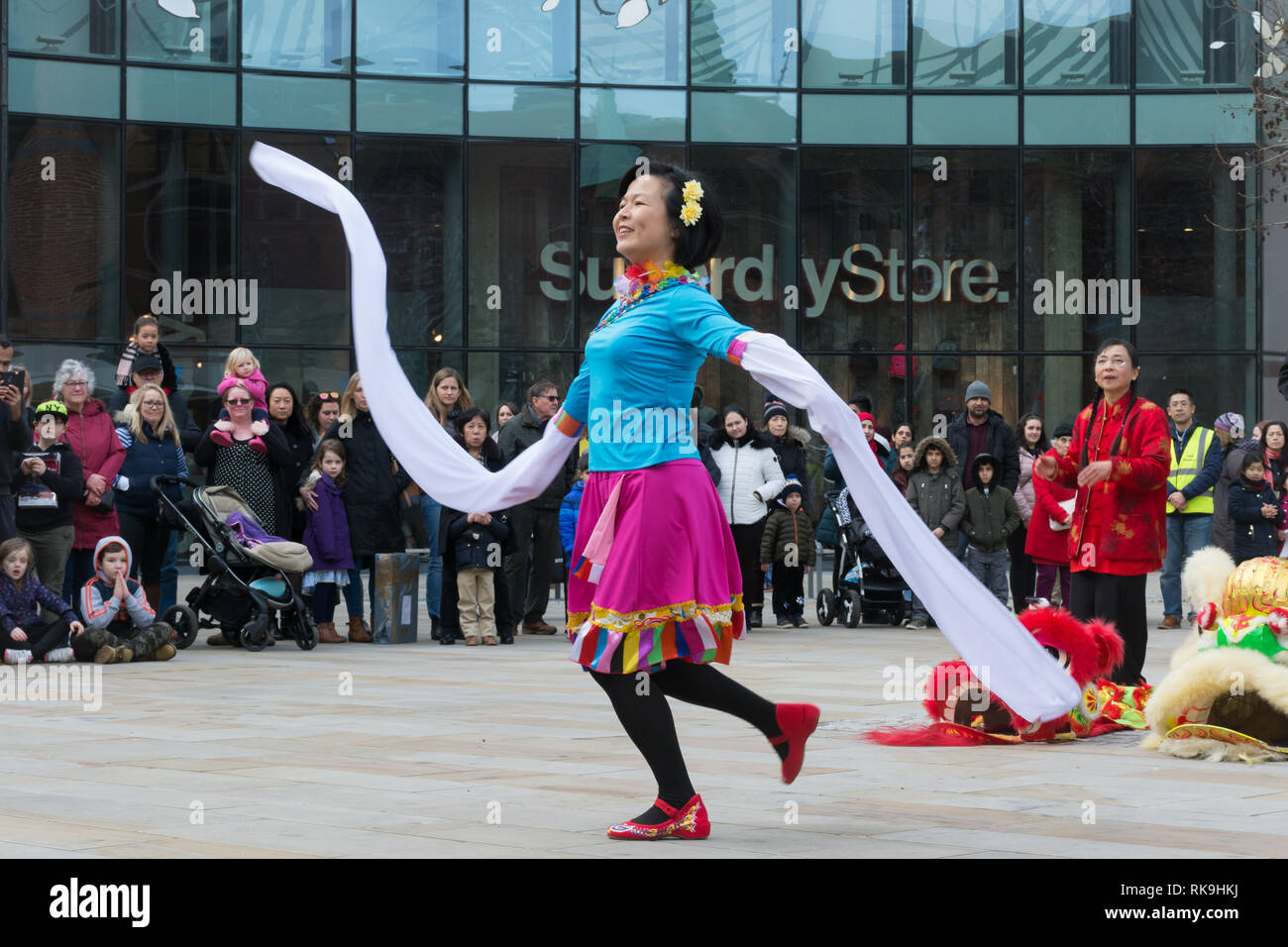 Tänzerinnen und Tänzer in farbenprächtigen Kostümen in einer Show im Chinesischen Neujahrsfest im Februar 2019 in Woking, Surrey, Großbritannien Stockfoto