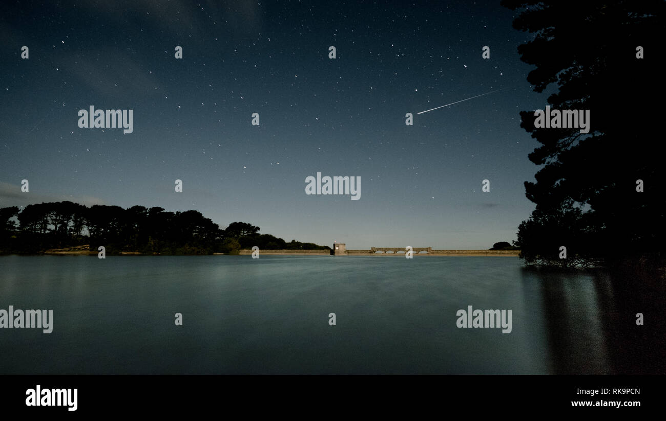 Nachthimmel mit Shooting Star über St Saviours Reservoir, Guernsey Stockfoto