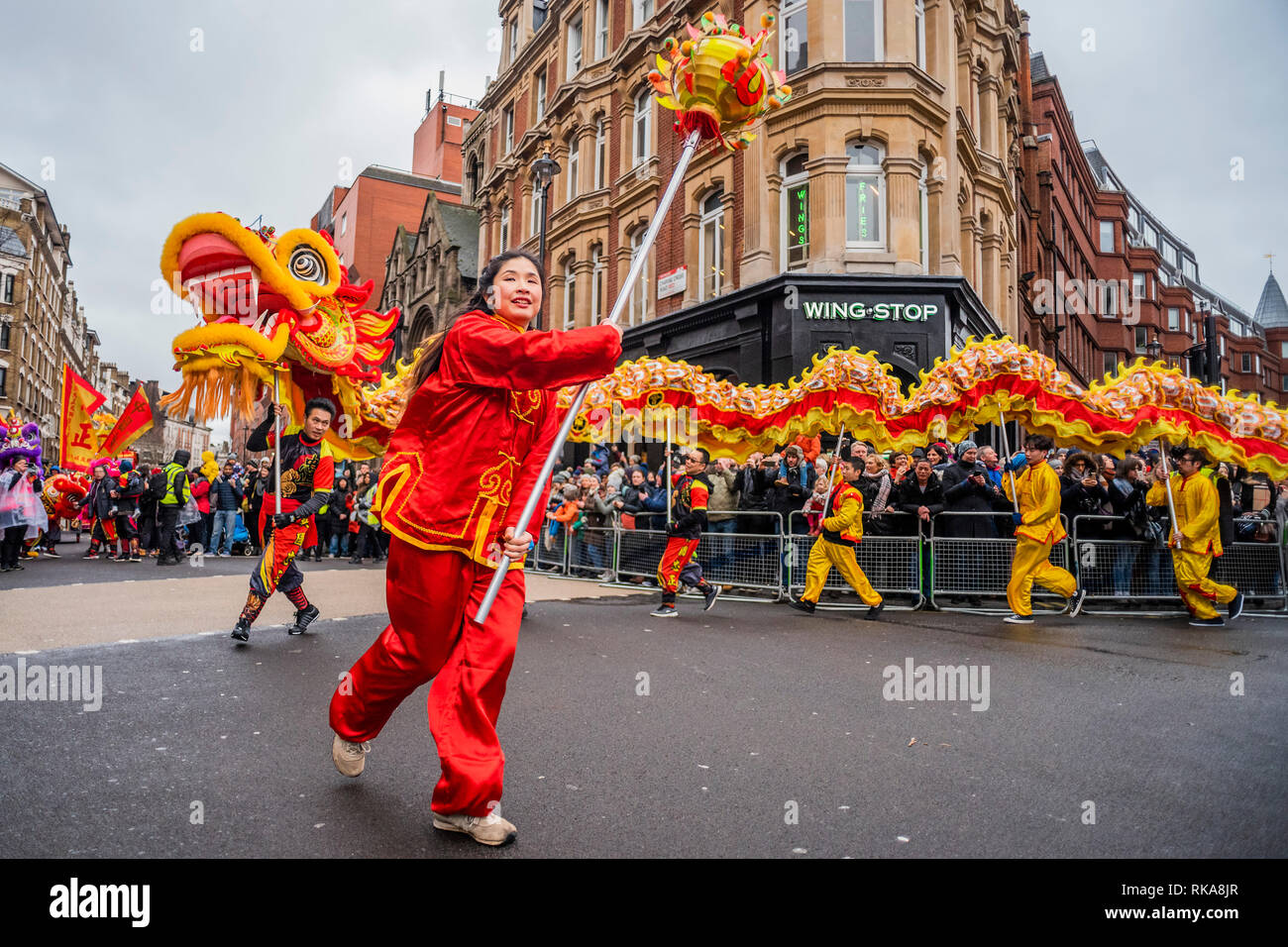 Lion Tänzer und Kinder in Kostümen Parade um die Ränder von Chinatown und Soho. Das chinesische Neujahr feiern in Soho, London. Stockfoto