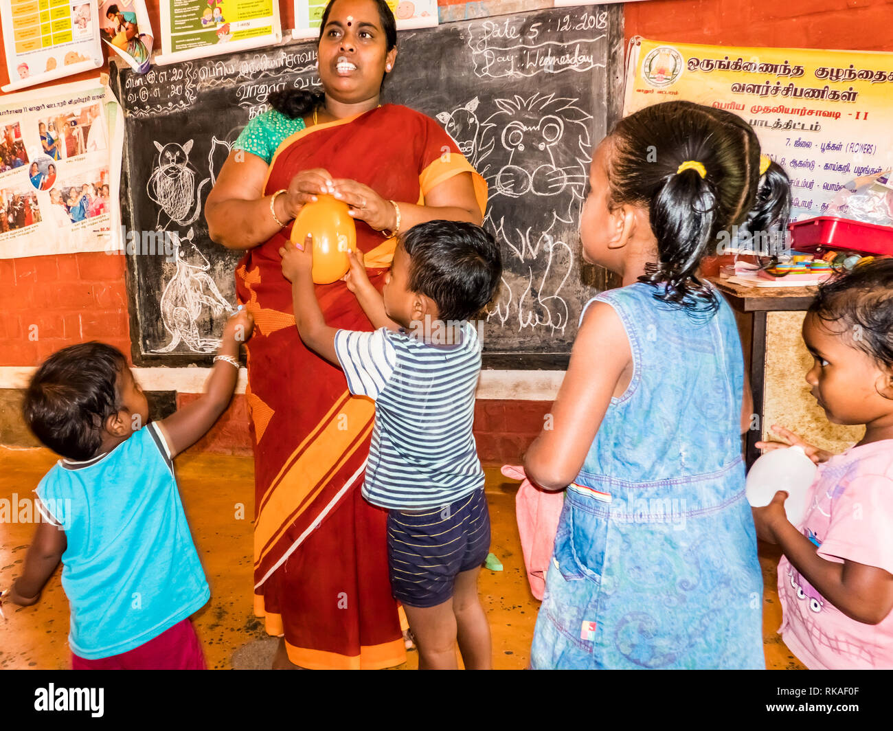 PUDUCHERY, Indien - Dezember Circa, 2018. Schlechte Vorschullehrer und ihre Gruppe Kinder Jungen Mädchen etwas Spaß in der Schule mit ein paar Holz Spielzeug g Stockfoto