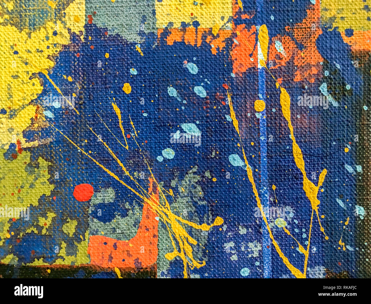 Helle gelbe Farbe Spritzer und Flecken auf blaue Hand bemalte Leinwand Hintergrund Stockfoto