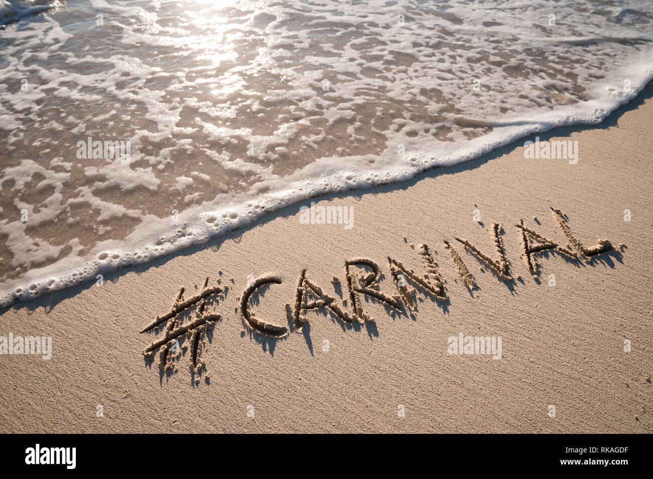 Moderne Nachricht für Karneval mit einem Social Media - freundliche Hashtag auf glatten Sandstrand geschrieben Stockfoto