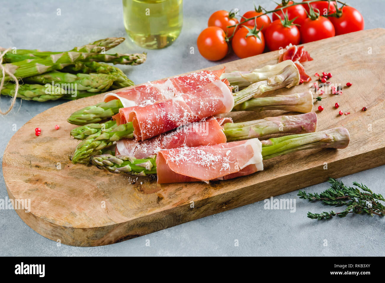 Frische organische Spargel in Schinken auf einem Schneidebrett gewickelt. Stockfoto
