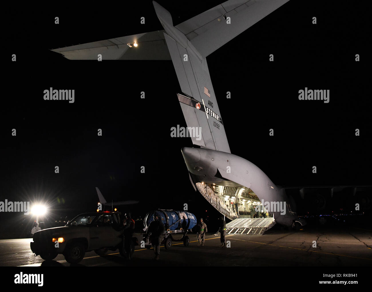 Flieger von der 104 Logistik Bereitschaft Squadron helfen ein Motor entladen aus einem C-17 Globemaster III von der 105 Luftbrücke Flügel in Stewart, New York Ausstattung vom Flugzeug zu entladen Feb 8, 2019 bei Barnes Air National Guard Base, Massachusetts. Flieger von der 104 Fighter Wing, die auf eine temporäre Aufgabe Belegung an Patrick Air Force Base in Florida waren home auf dem C-17 zurück. (U.S. Air National Guard Fotos von Airman Sara Kolinski) Stockfoto