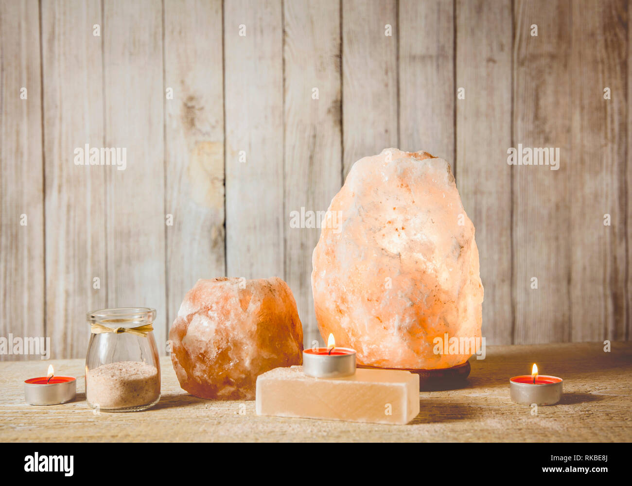 Himalaya-salz SOAP Bar, Rosa Rock salt-Lämpchen und Salz Kerzenhalter mit Kerze im Inneren, jar mit Salz Körner auf Licht bokeh backgro Stockfoto