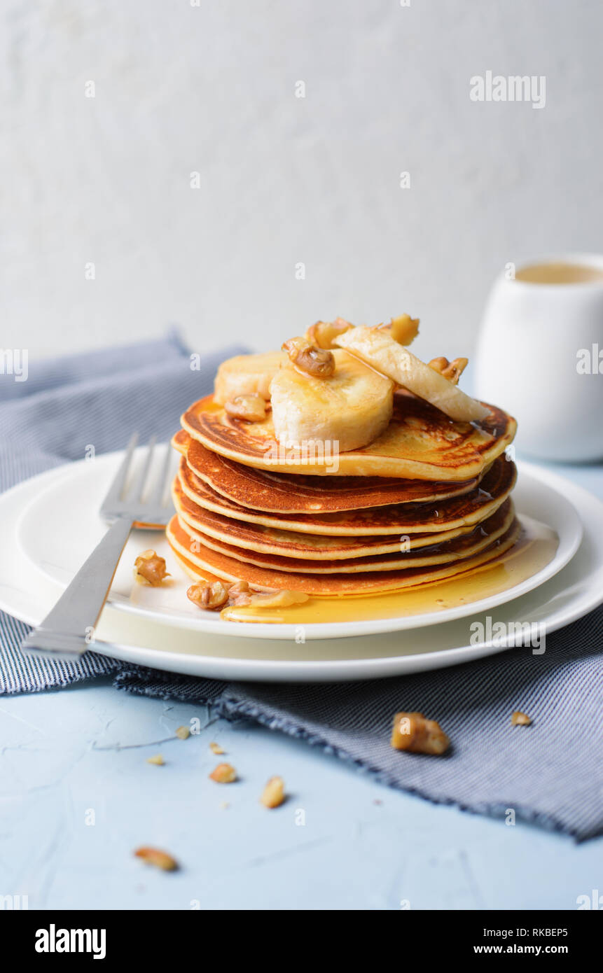 Stapel von hausgemachte Pfannkuchen mit Banane, Nüssen und Honig, Glutenfrei Haferkleie Pfannkuchen, gesundes Frühstück Stockfoto