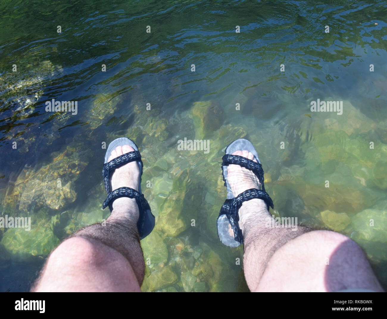 Junger Mann Füße im Wasser des Flusses. Im Sommer entspannen. Treska Fluss, Mazedonien Stockfoto