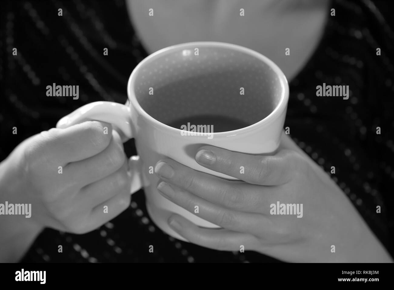 Hände halten Kaffee am Morgen, schwarze und weiße Monochrome Stockfoto