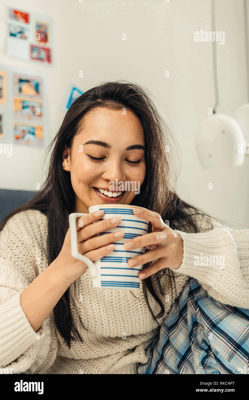 In der Nähe der schöne asiatische Frau mit großen weißen Tasse Tee Stockfoto