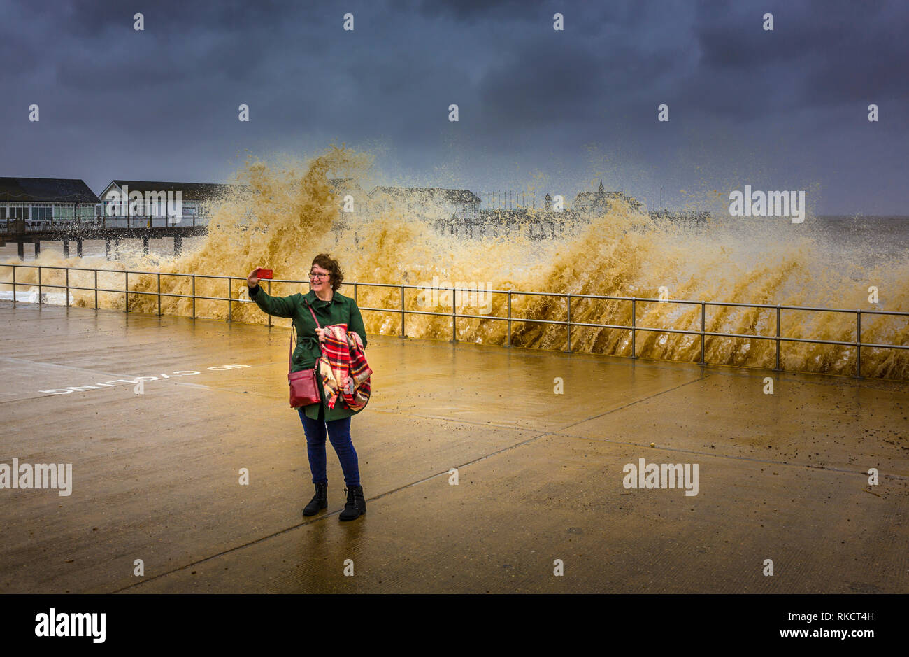 Southwold, Suffolk, Großbritannien. 30.April 2018. Eine Dame nimmt eine selfie vor der rauen See in Southwold Pier. Southwold, Suffolk, Großbritannien. Stockfoto