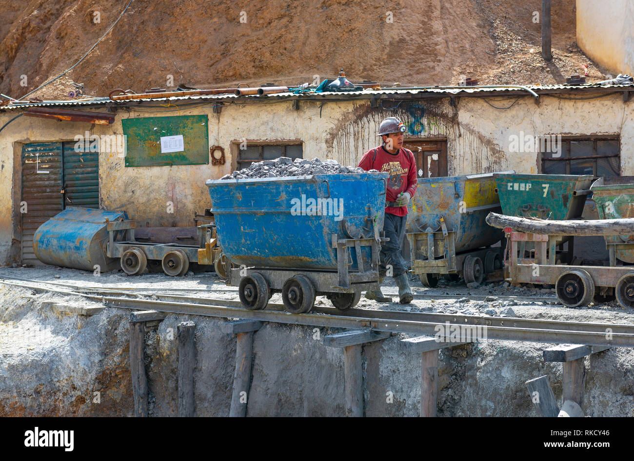 Ein bolivianischer Bergmann mit einem Schlitten gefüllt mit Steinen, in Silber durch eine Mine Welle des Cerro Rico in der Stadt Potosi, Bolivien. Stockfoto