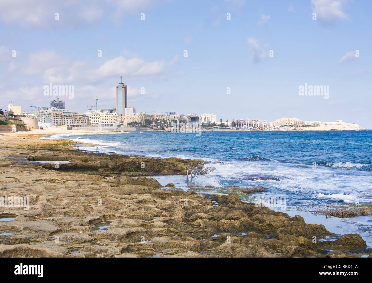 Blick entlang der Küste zu Fuß in St. Julians Malta, herbstliche Sonne und Mittelmeer blaue Meer macht es zu einem beliebten Ferienziel Stockfoto
