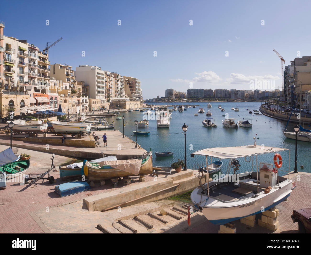 Spinola Bay in St. Julian's Malta eine geschützte Bucht mit Fischerbooten, Verkehr, Restaurants und Unterkünfte für Touristen Stockfoto