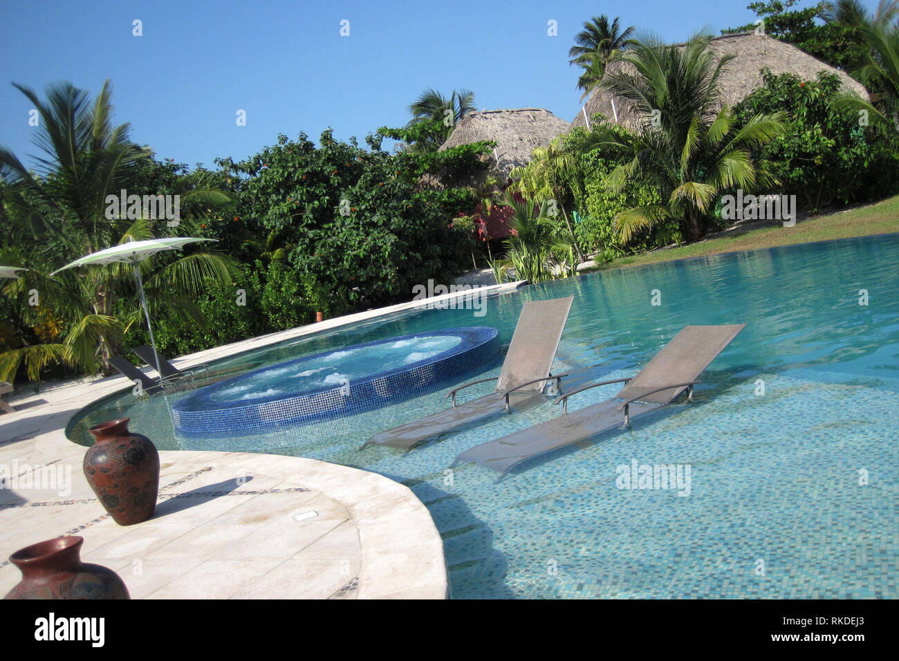 Zwei Liegestühlen sitzen in einem Pool in einem Resort in Belize. Stockfoto