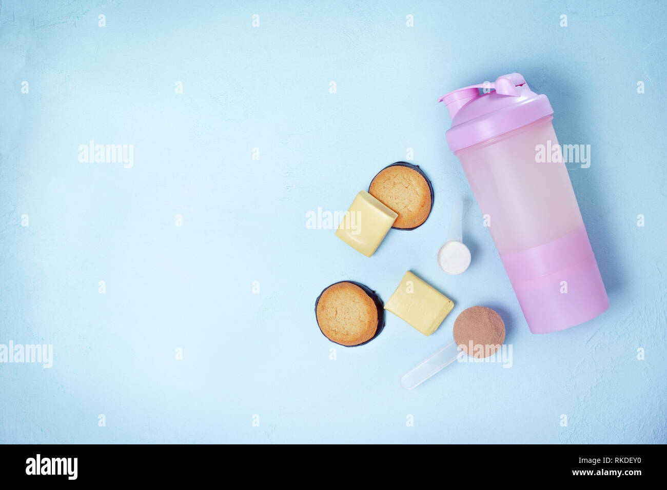 Schütteln mit Protein Drink, Protein Pulver, protein Bars und Protein cookies auf einem blauen Hintergrund. Blick von oben. Kopieren Sie Platz Stockfoto