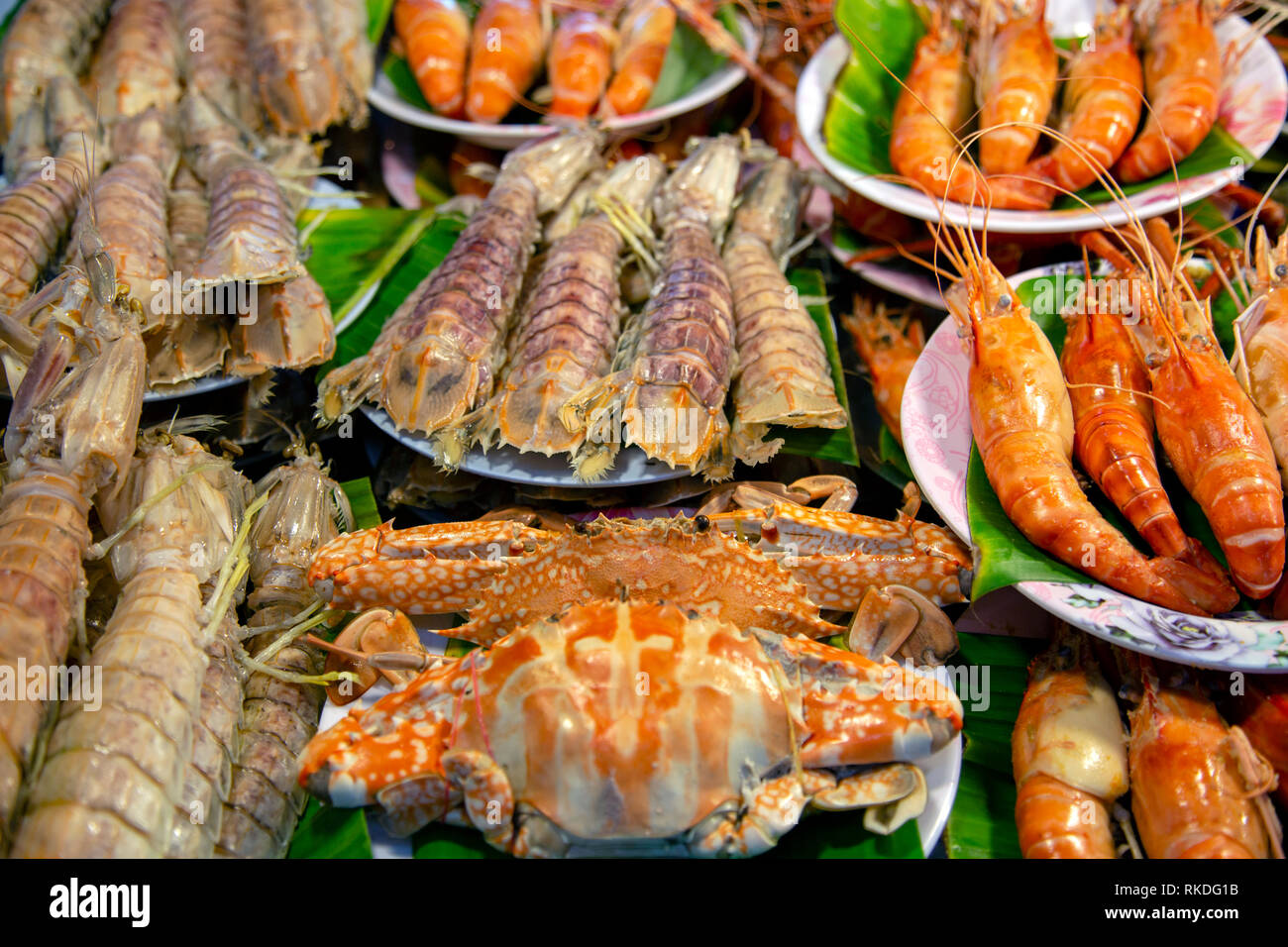 Eine Anordnung von gekochte Krabben, Garnelen, Garnelen, Mantis Garnelen Schalentiere krustentier Meeresfrüchte in einem Fischmarkt essen in Phuket, Thailand. Stockfoto