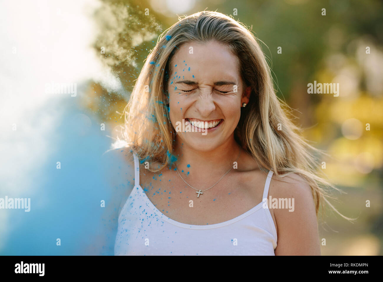 Lächelnde Frau ihre Augen schließen während der Wiedergabe von Holi. Holi Farbe Puder auf eine lächelnde Frau geworfen. Stockfoto