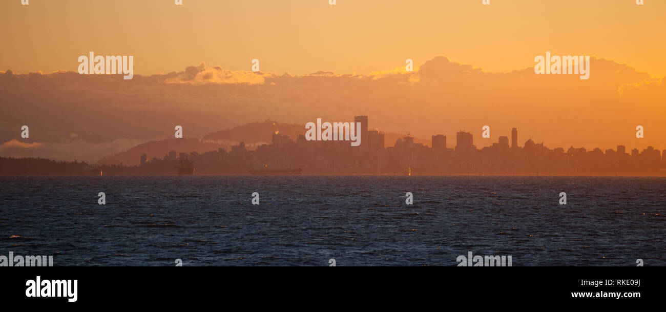 Panoramische Sicht auf die Vancouver City Skyline bei Sonnenaufgang mit Hintergrund Wolken vom Boot auf dem Pazifik in British Columbia, Kanada gesehen Stockfoto