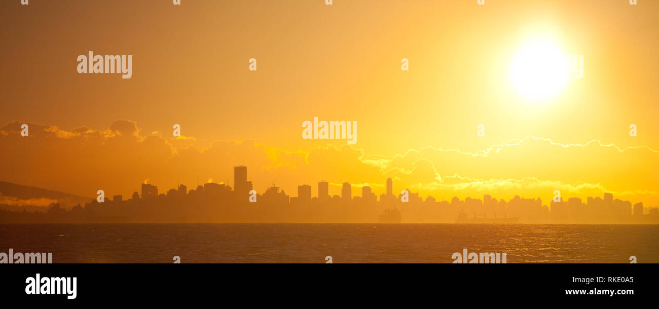 Panoramablick auf die helle Morgensonne über dem Vancouver City Skyline von einer Fähre in der Georgia Straight in British Columbia, Kanada gesehen Stockfoto