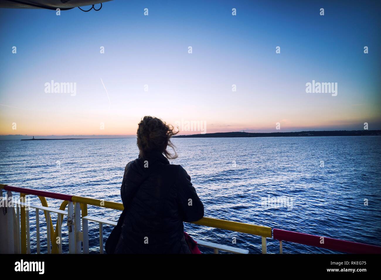 Silhouette der unkenntlich Frau auf dem Deck der Fähre im Hafen. Mittelmeerküste, Mahon, Menorca, Balearen, Spanien Stockfoto