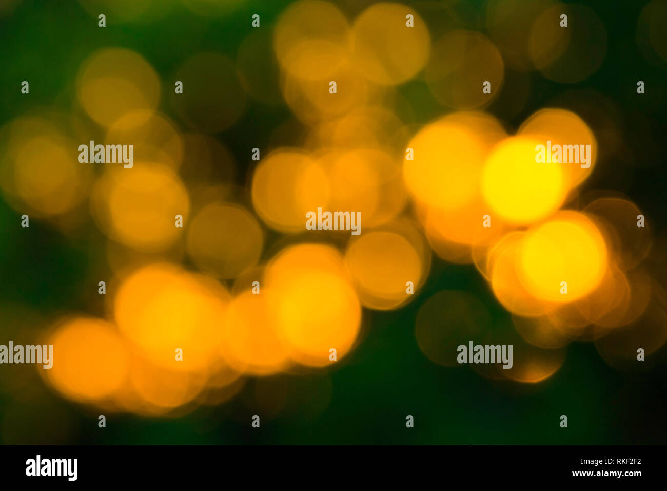 Gelbe Bokeh Kugeln abstrakte Textur auf grünem Hintergrund. Farbenfroh. De fokussierte Hintergrund. Helles Licht verschwimmen. Runde Punkte. Stockfoto