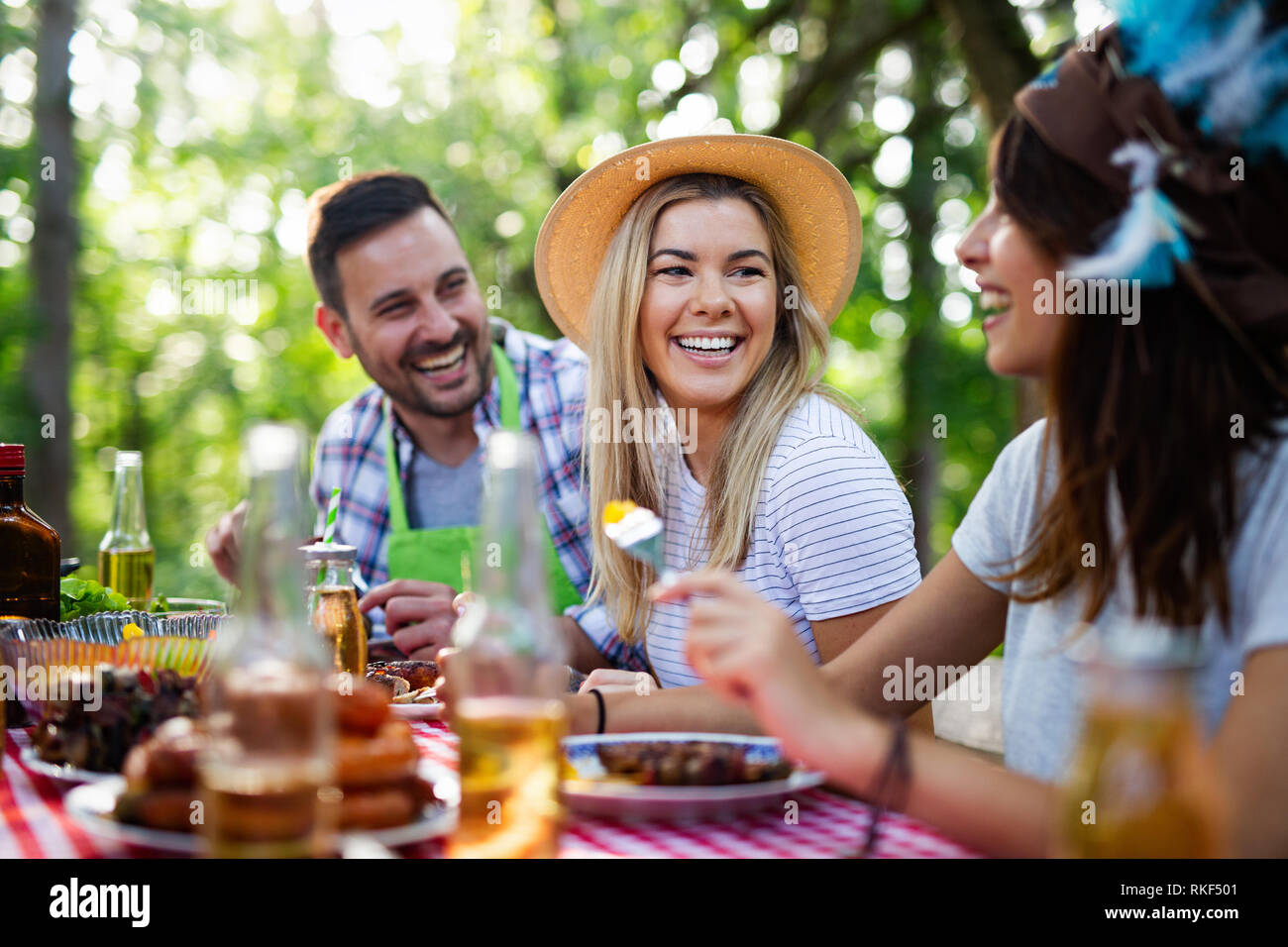 Gruppe der glücklichen Freunde essen und trinken Biere an Barbecue Dinner Stockfoto