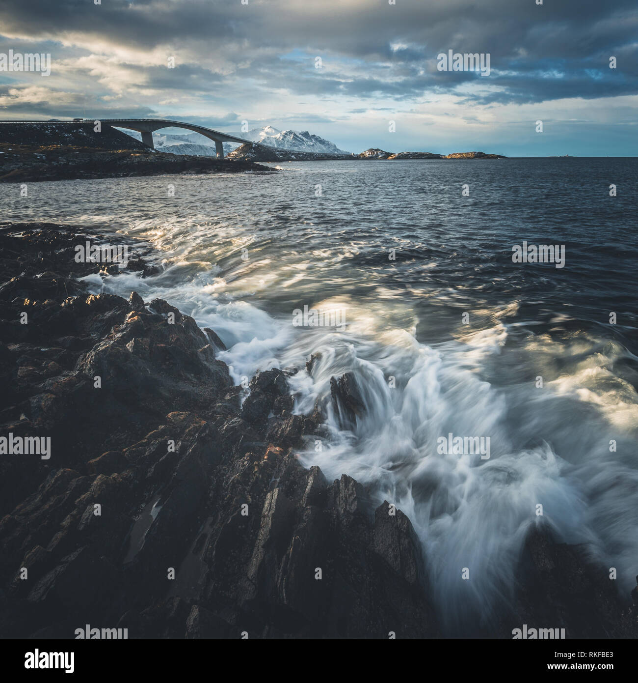 Felsige Küste am Atlantik Straße in Norwegen. Lange Belichtung Schüsse. Blick auf die berühmte Brücke Storseisundbrua und brechende Wellen. Stockfoto