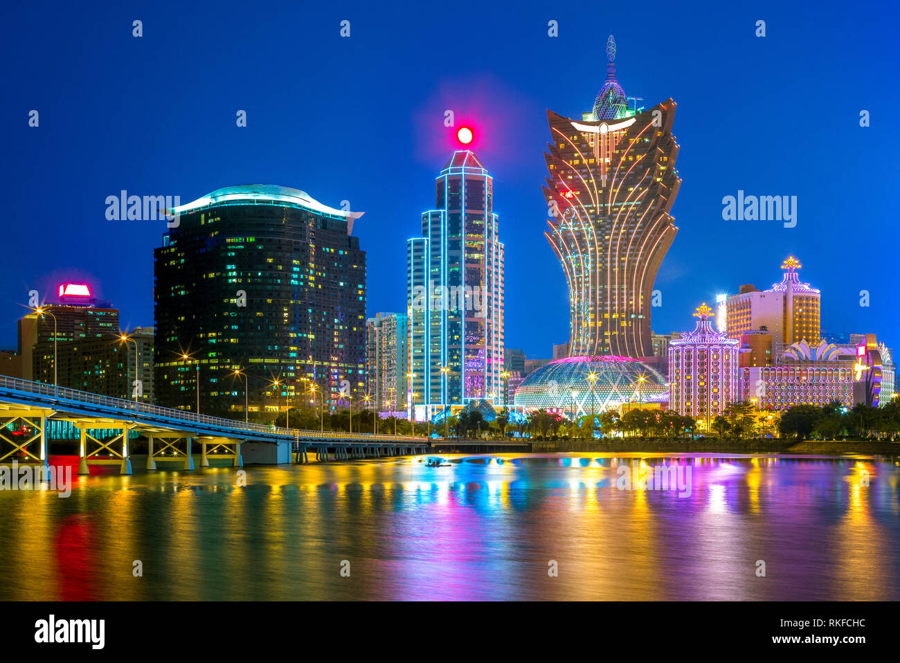 Die Skyline von Macau durch das Meer bei Nacht in China Stockfoto