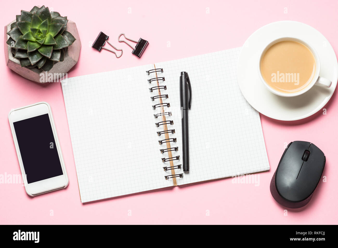 Büro Arbeitsplatz mit Notepad, Kaffee Tasse und Tastatur auf rosa Schreibtisch. Stockfoto