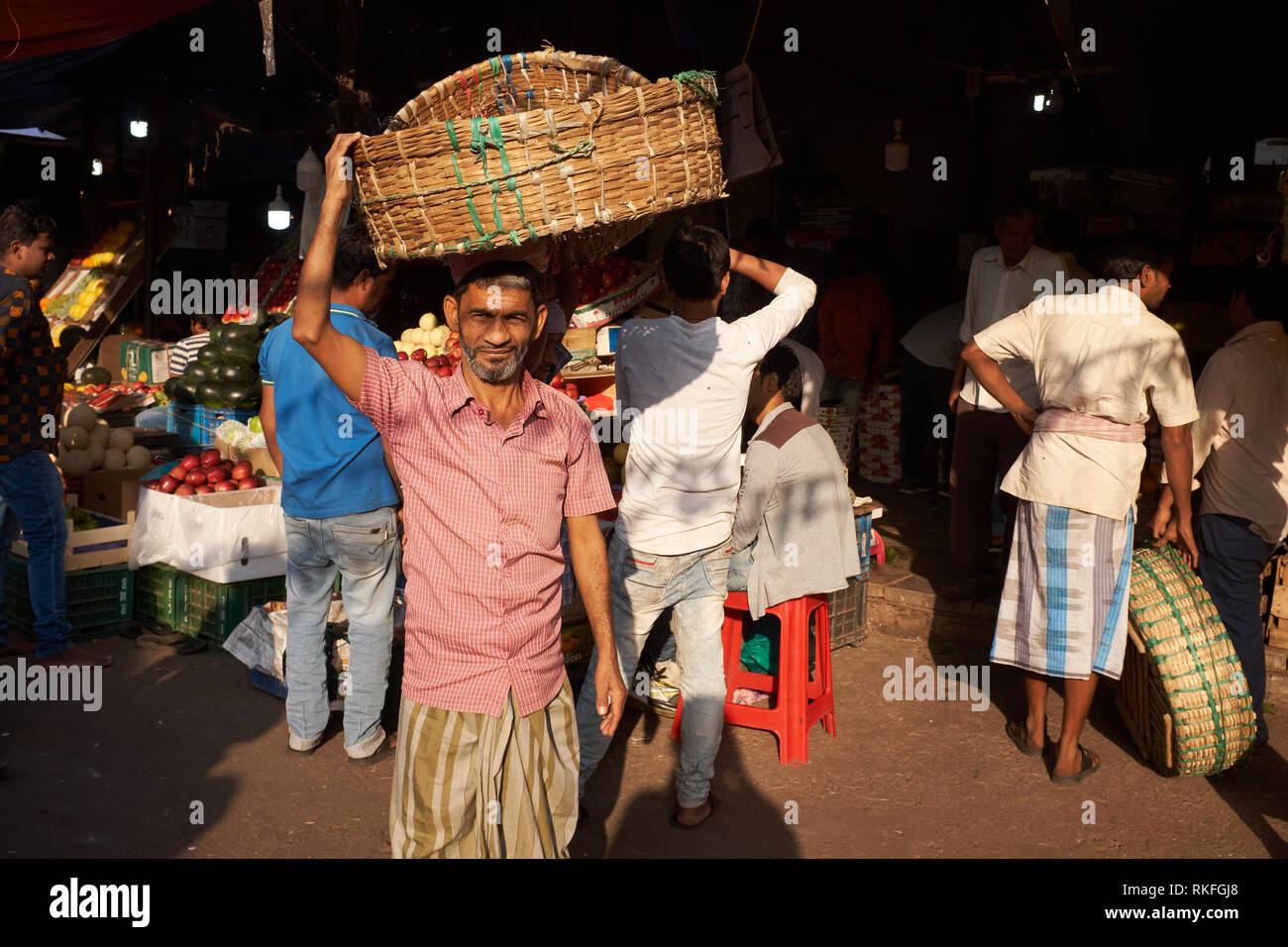 Ein Torhüter mit seinem Korb bei Crawford Market von Mahatma Jyotirao Phuke Markt, ein Großmarkt für Obst und Gemüse in Mumbai, Indien Stockfoto