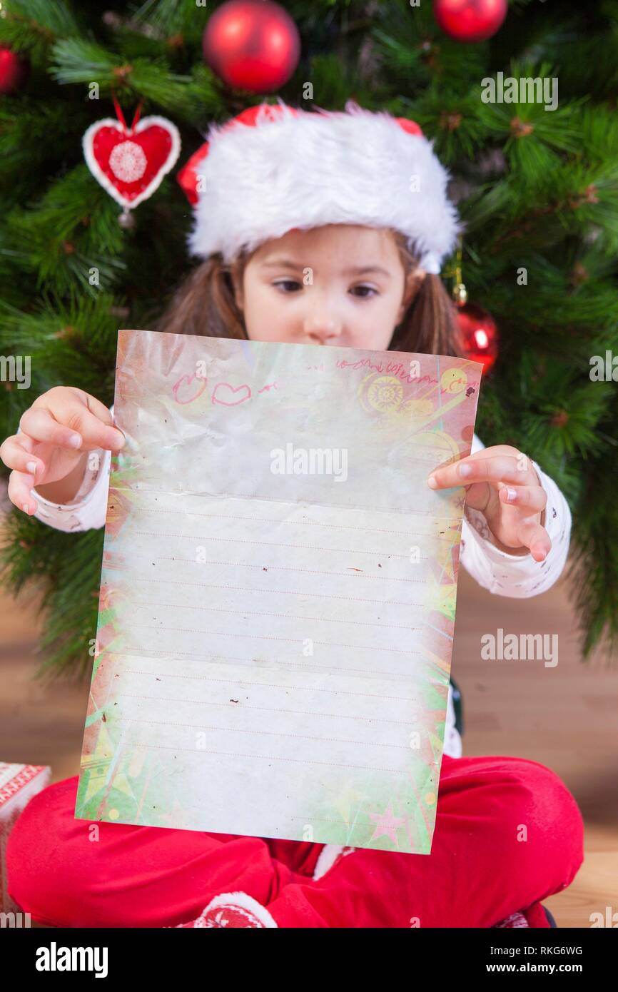 Kleines Mädchen mit den Santa schreiben. Sie malte das Blatt. Stockfoto