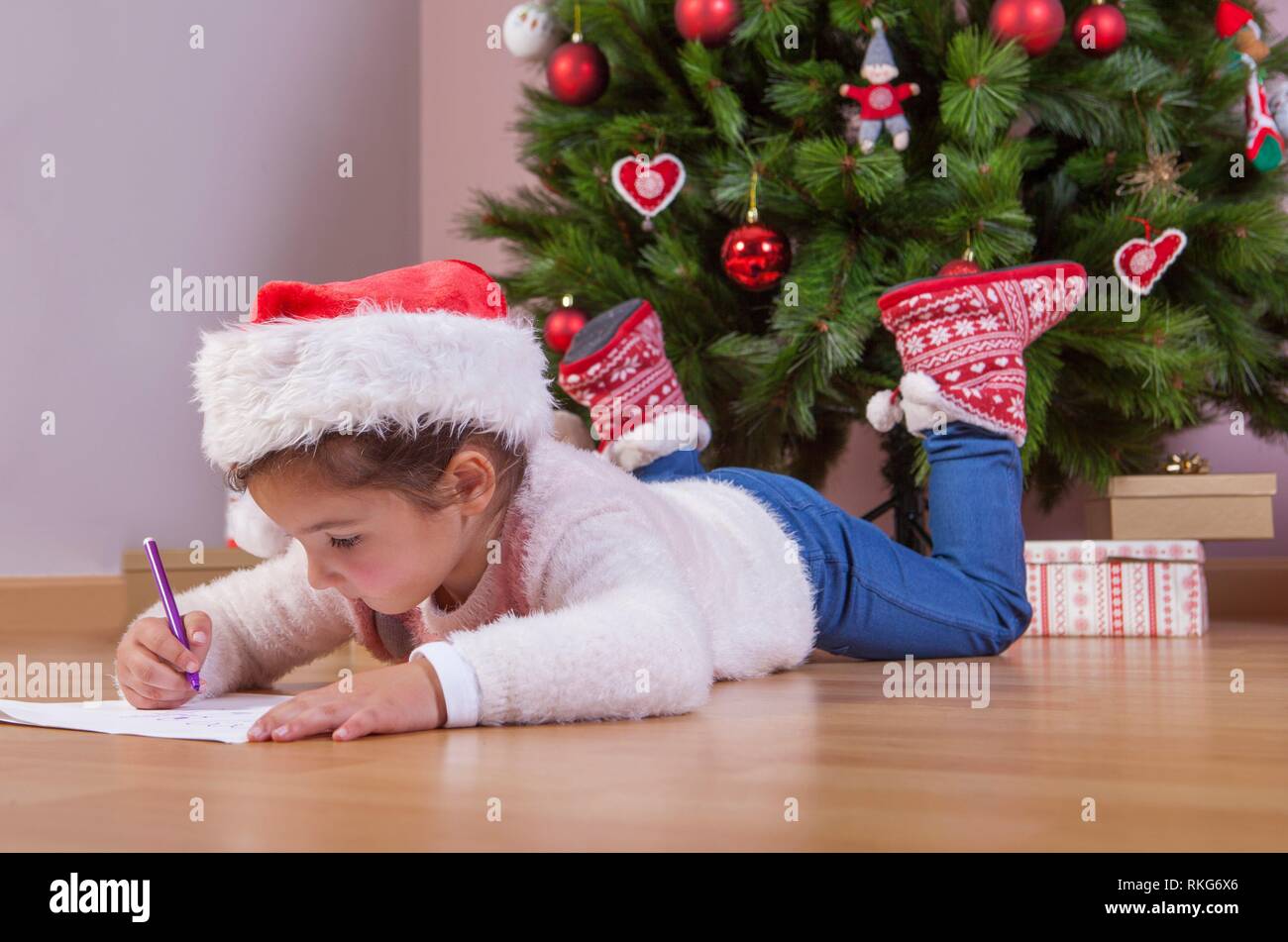 Kleine Mädchen die Vorbereitung der Santa schreiben. Sie malen die Geschenke, die Sie möchten. Pre-reader Konzept. Stockfoto