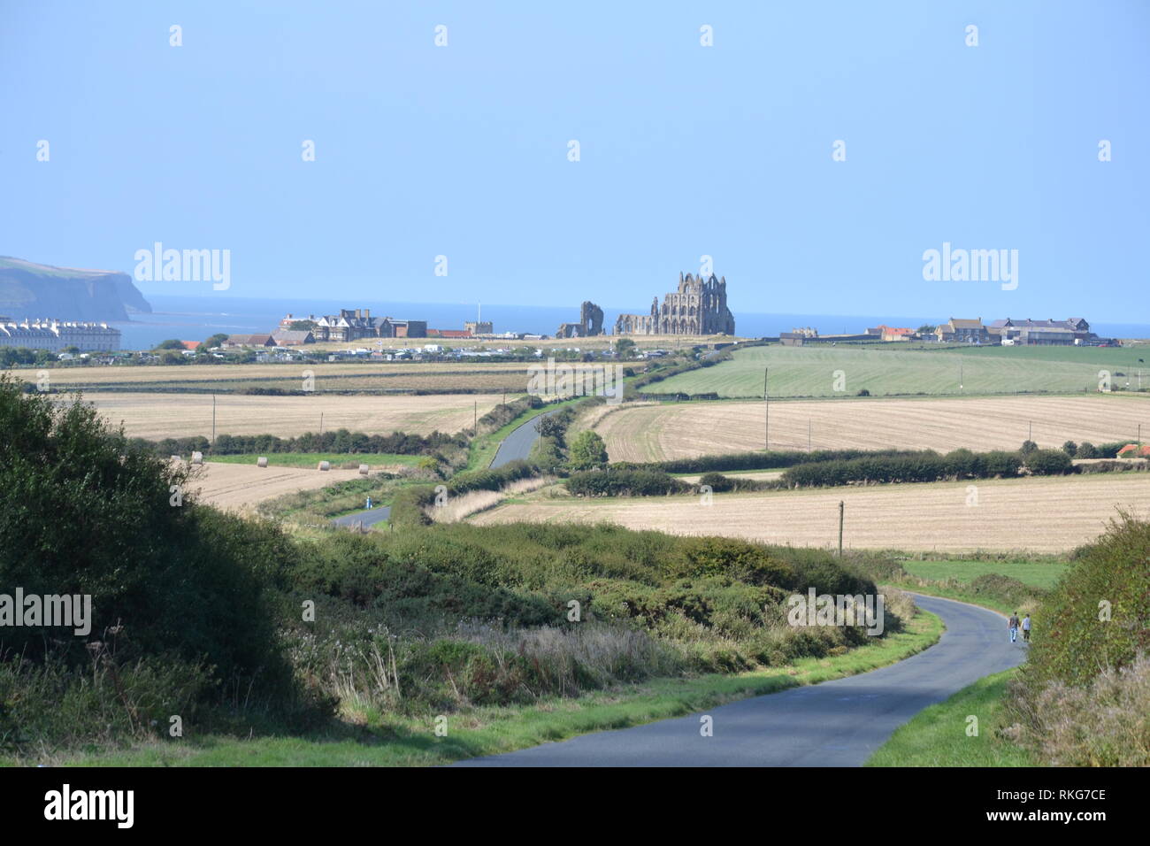 Lange Windy Country Road Nach Whitby Abbey - Landschaft - Blick auf Whitby Abbey - Sonnentag - Bauernfeld - Sommerfrüchte - Küste - Yorkshire UK Stockfoto