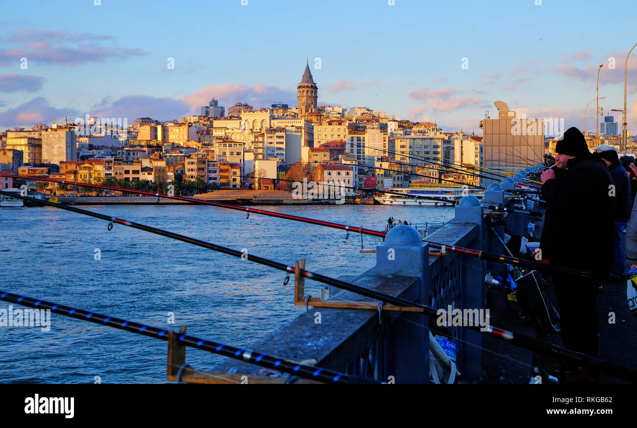 Fischer auf der Galata Brücke Leuchten am späten Nachmittag Sonne. Pisten von Karaköy und Galata Turm erscheinen im Hintergrund. Istanbul, Türkei - Dezember Stockfoto